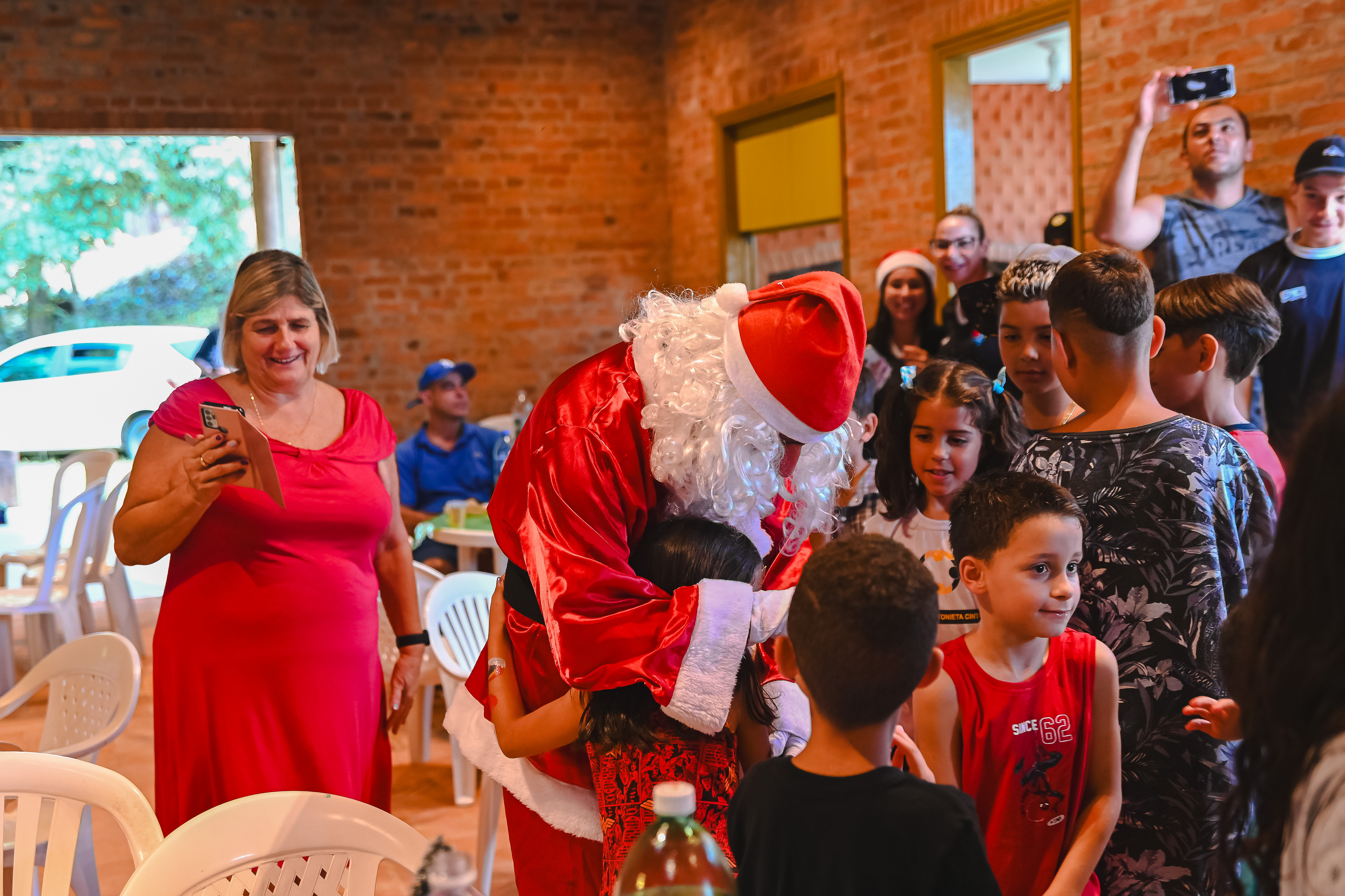 Crianças abraçando o Papai Noel no Natal Solidário 2023